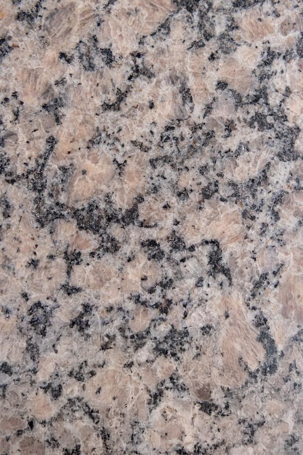 The Encore apartment homes with Close-up of a light-colored granite surface with black, white, and pinkish speckles and veins.