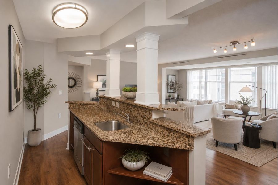 The Encore apartment homes with Modern open-concept living room and kitchen with granite countertops and neutral-toned decor.